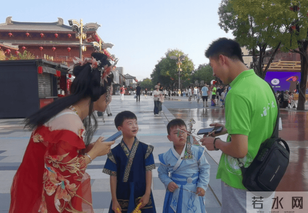 图为团队成员向游客介绍皮影