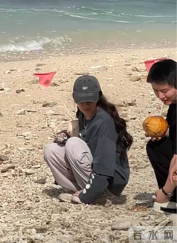 郭碧婷现身三亚情人岛 素颜穿着朴素 怀里抱着椰子 蹲在沙滩上捡石头