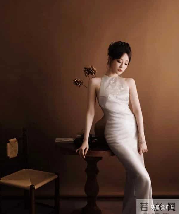 祝绪丹，身穿紧身拖尾旗袍礼服，端庄大方