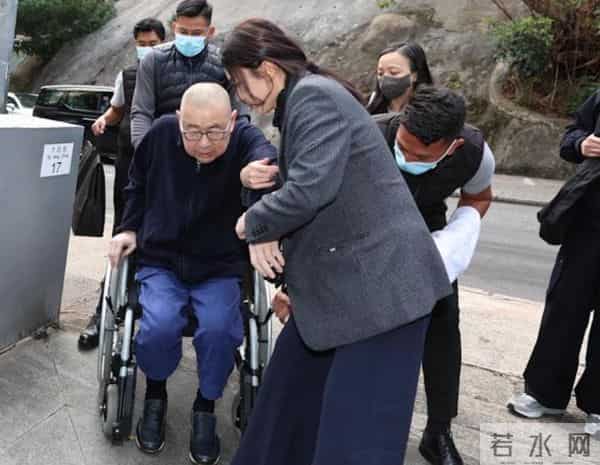 74岁刘銮雄携妻子现身，紧紧扶住甘比的手，女方看着疲惫很无奈