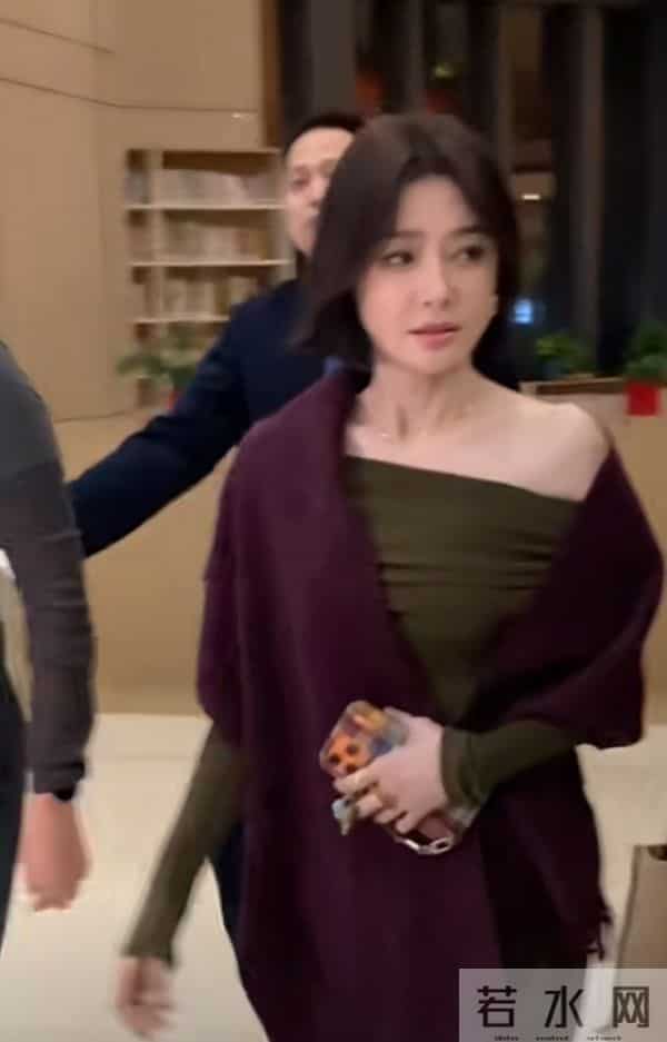 秦岚抵达广州出席活动，墨绿长裙搭酒红披巾，短发超有韵味