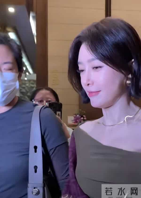 秦岚抵达广州出席活动，墨绿长裙搭酒红披巾，短发超有韵味