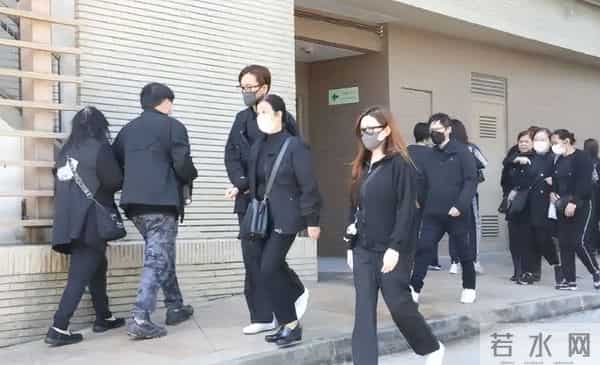 马国明父亲出殡。他手捧遗照神情哀伤，妻子汤洛雯陪伴左右