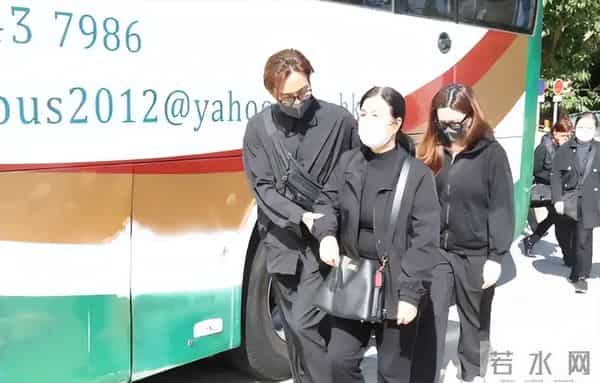 马国明父亲出殡。他手捧遗照神情哀伤，妻子汤洛雯陪伴左右