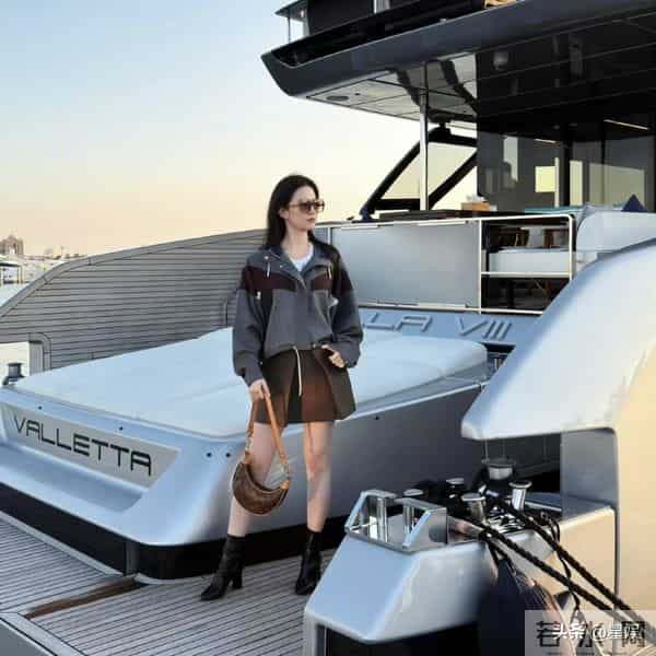 游艇上，刘亦菲短款撞色外套利落飒爽，搭配工装风短裙与复古靴