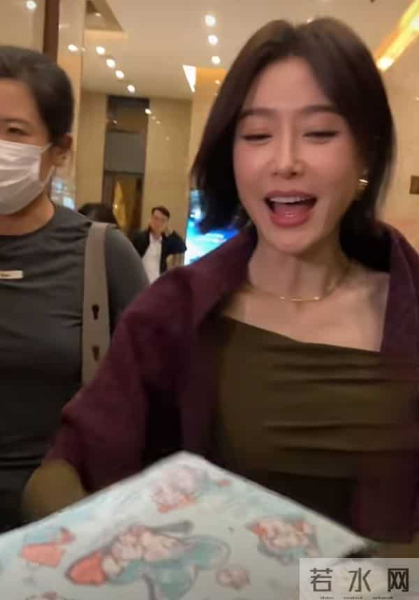 秦岚抵达广州出席活动，墨绿长裙搭酒红披巾，短发超有韵味