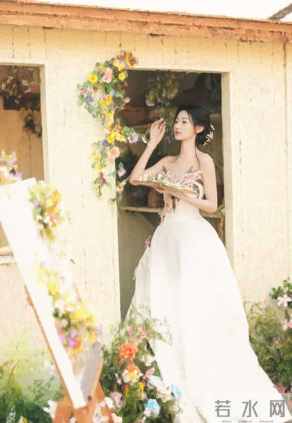 白裙缀着粉瓣似的褶皱,浸在满院花簇的软光里